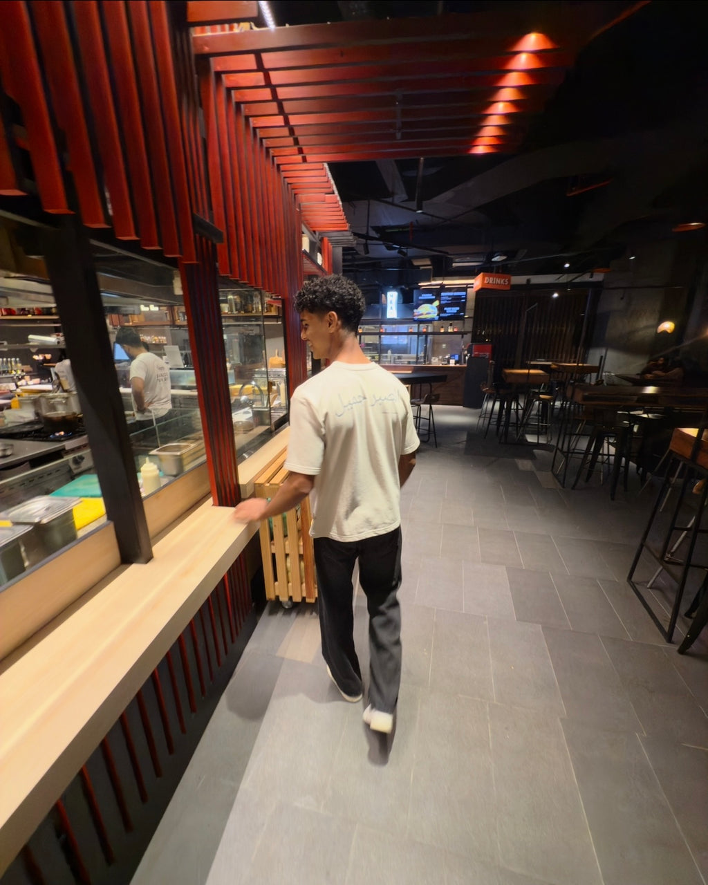 Person walking through a modern restaurant with wooden interior design